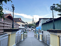 we will take a leisurely walk along The Chansom Memorial Foot Bridge, a bridge connecting the Wat Ket neighborhood with Kad Luang